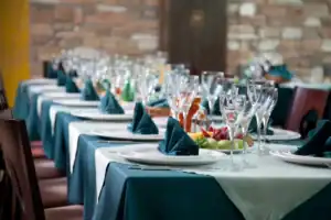 Marquee dining arrangement with tableware and glassware for outdoor celebrations.