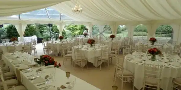 Beautiful marquee interior with round tables and floral centrepieces for special events.