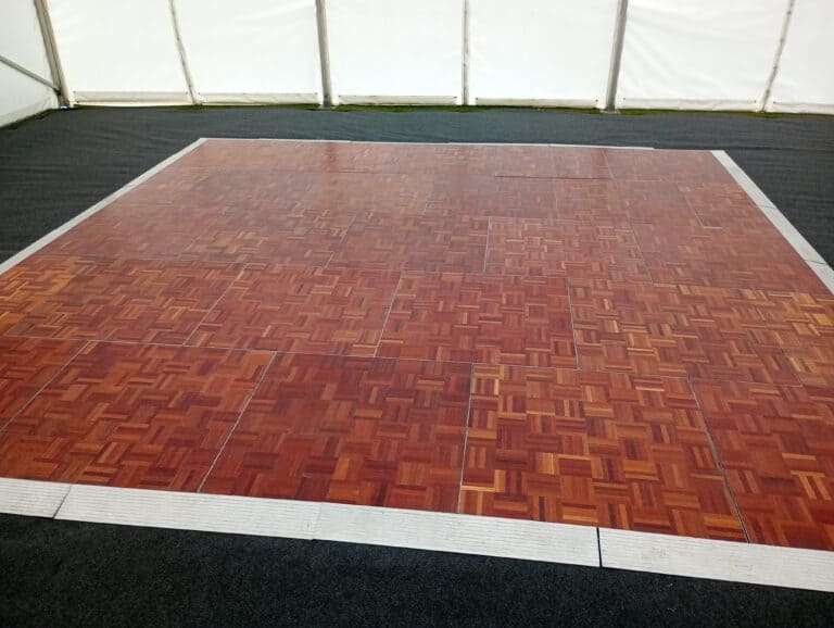 Dance floor with wooden parquet finish inside marquee.